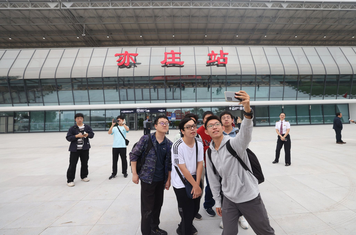 乘客在亦庄火车站前合影留念。新京报记者 王贵彬 摄