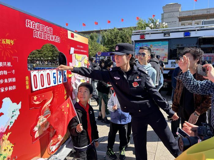 “为民服务车”执勤民警为游客介绍“向祖国母亲表白”展板。 新京报记者 彭镜陶 摄