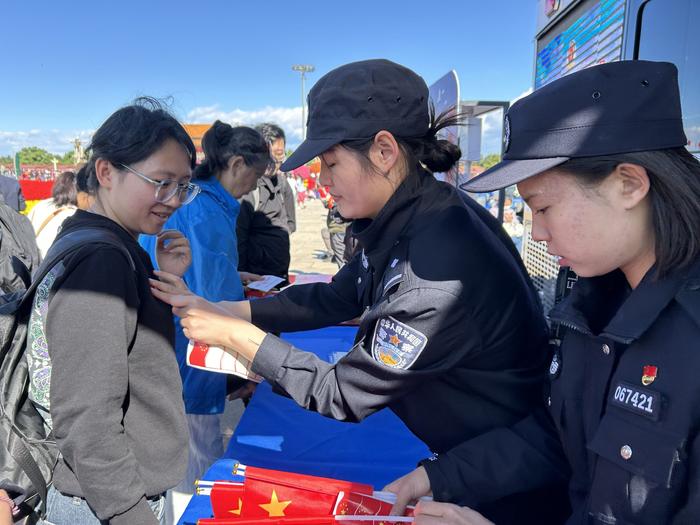 “为民服务车”执勤民警为游客贴国旗贴纸。 新京报记者 彭镜陶 摄