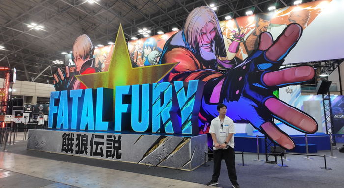 TGS上《饿狼传说》展位上的巨大LOGO相当显眼，现场许多观众也都背着SNK放送的巨大置物袋