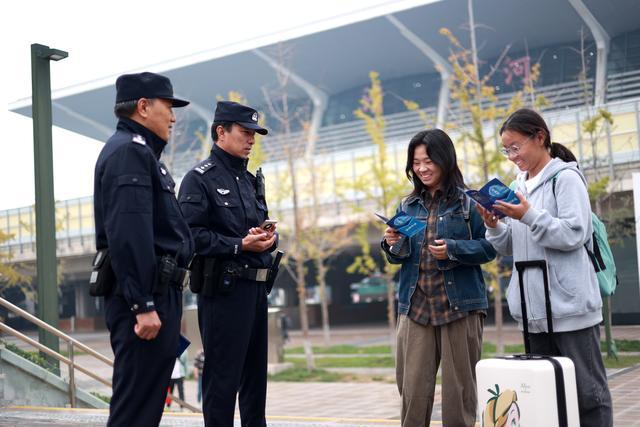 民警王建军和厉亮为过往游客开展反诈宣传。图源：海淀警方