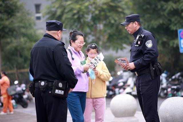 民警为游客发放火车站服务指南手册。 图源：海淀警方