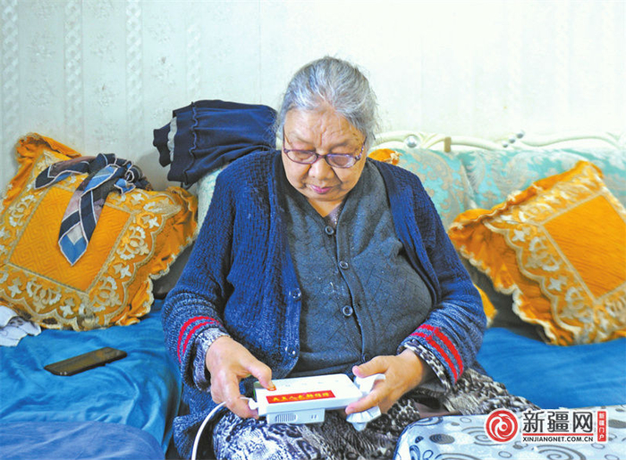10日，水韵康居苑小区100岁独居老人托乎提汗·肉孜展示她的“爱心和谐铃”呼叫器。（全媒体记者雷婷摄）