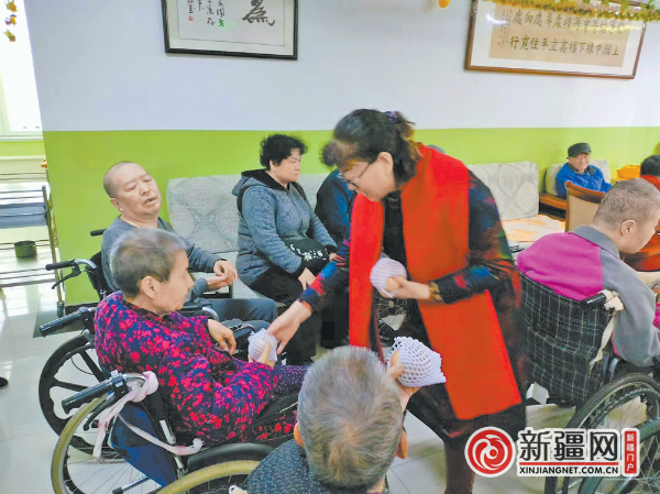 退休教师赵俊梅（右一）与博爱公益团队来到养老院与老人一起过重阳节。（全媒体记者梁淑芳摄）