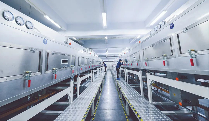 多氟多新能源锂电池生产线工人在对电池配件进行烘干处理。