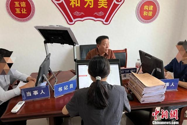 岚角山法庭政法“五老”调解员何放（中）。中新网 张钰惠 摄