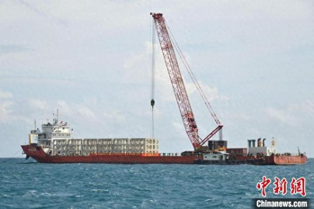 10月15日，在海南三亚西岛附近海域，一艘大型工程船正在进行人工鱼礁投放作业。张月和 摄