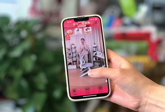 2024年10月10日，北京一名消费者在观看商家的店播（周开艳/摄）