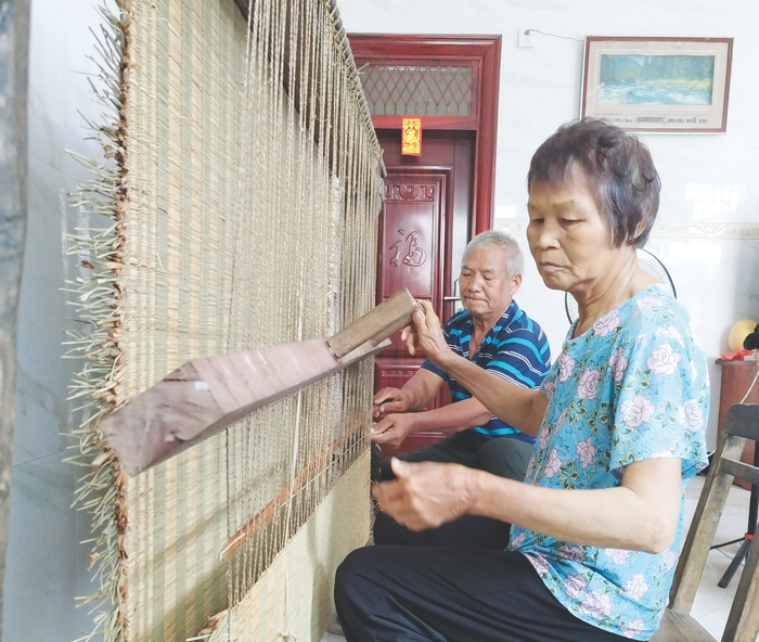     黄家敏夫妇以娴熟的技艺编织草席。    （谭欢 摄）