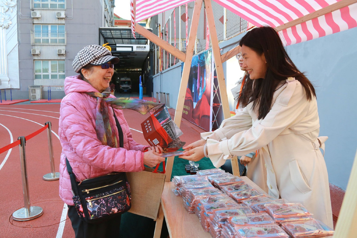 10月19日，返校校友领取校园文创纪念品。学校供图