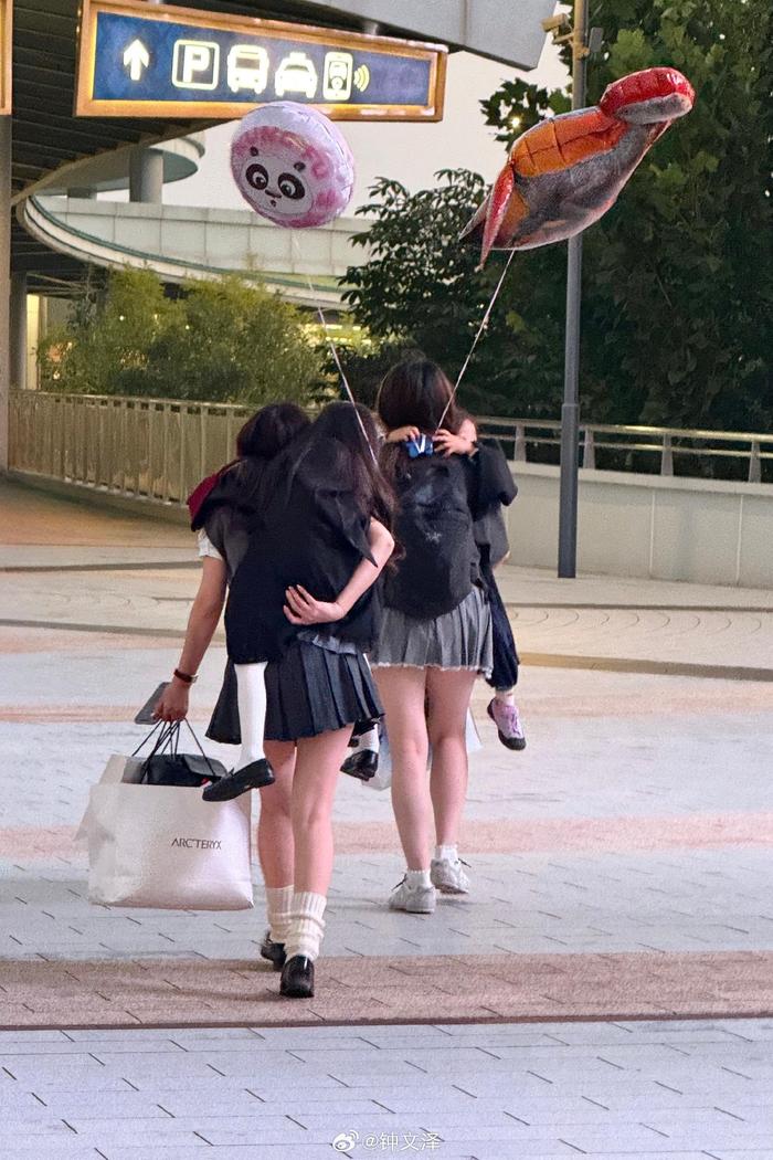 从环球影城往外走的时候看见两个打扮漂亮的女孩，分别拉扯着自己的小朋友