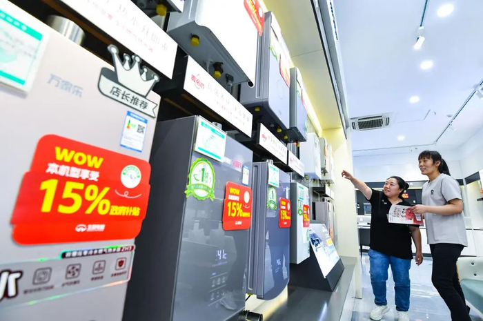 ▲图为贴有补贴标识的家电卖场一角，销售人员在为市民介绍补贴政策及产品。