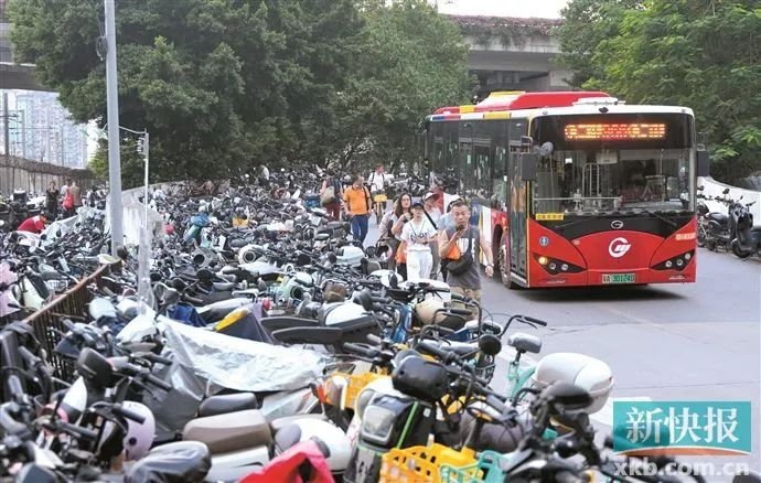 电动自行车停放至马路上，公交车为了避让行人和电动自行车，只能在道路中间的黄线上行驶。