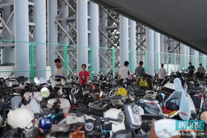 地铁坑口站周边的空地停满电动自行车。