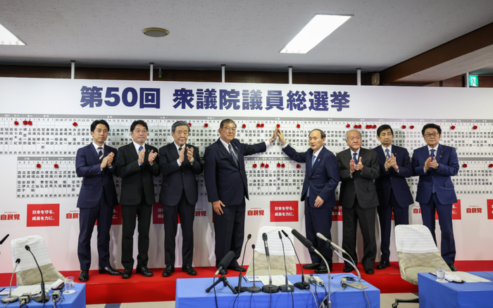 ▲10月27日，在日本东京自民党总部，石破茂（右）和小泉进次郎将象征成功当选的红花贴在候选人名字上。图/新华社