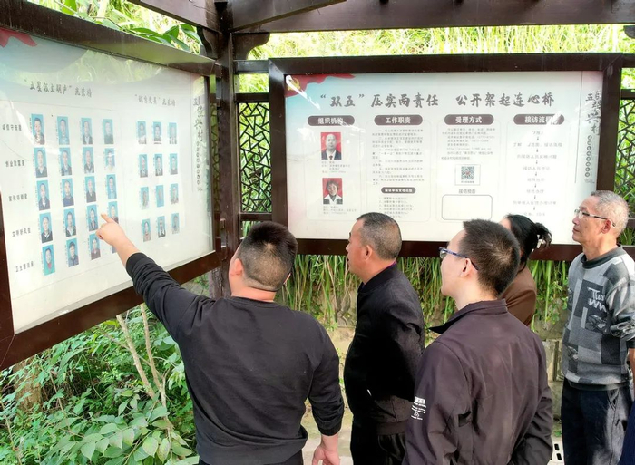 村民们正在讨论“光荣榜”。邹刚 摄