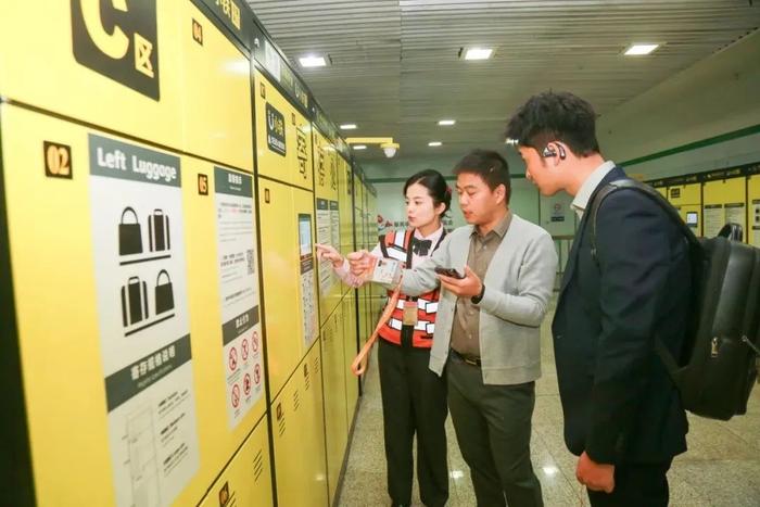 在国家会展中心地铁站,工作人员为参会人员讲解寄存柜如何使用。澎湃新闻记者 陈逸欣 图
