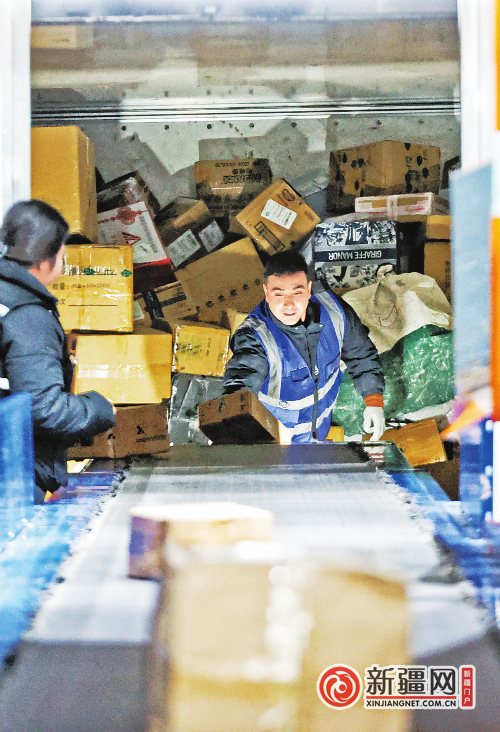11月8日，在新疆邮政乌鲁木齐邮区中心邮件处理中心，工作人员将快递装车。（全媒体记者迪丽娜尔·加力肯摄）