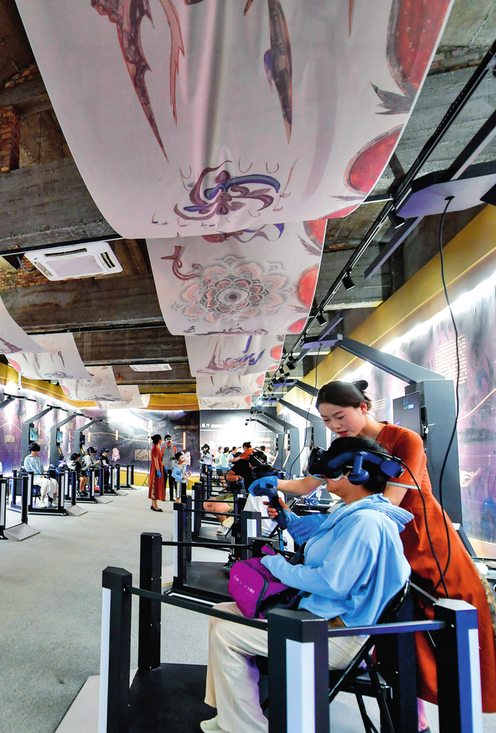 游客在敦煌体验“寻境敦煌——数字敦煌沉浸展”（2024 年 7 月 22 日摄） 郎兵兵摄