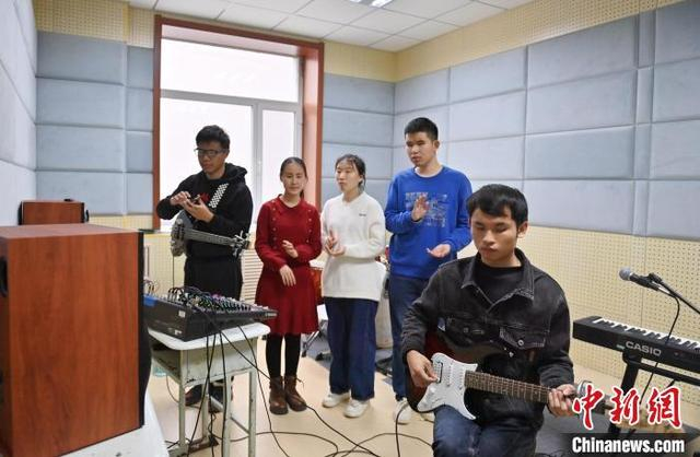 11月14日，吉林长春，“逐暗逐光”乐队成员在听音乐。中新社记者 张瑶 摄 