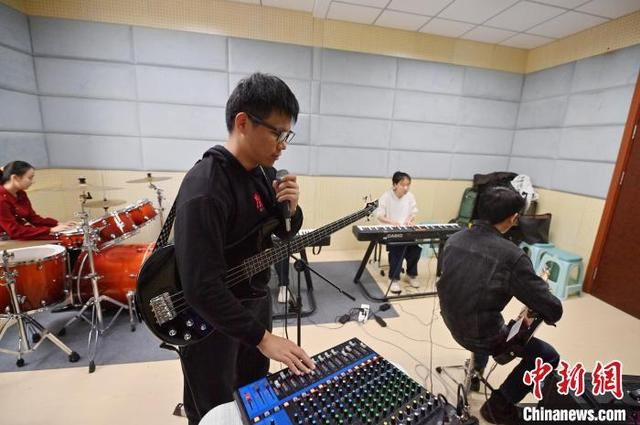 11月14日，吉林长春，“逐暗逐光”乐队发起者楼林昊天在调试调音台。中新社记者 张瑶 摄 