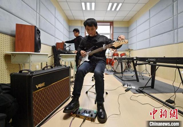 11月14日，吉林长春，“逐暗逐光”乐队成员黄毅弘在弹电吉他。中新社记者 张瑶 摄 