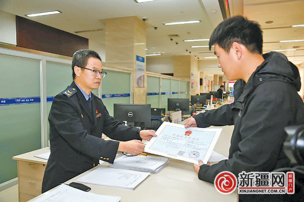 在经开区（头屯河区）政务服务中心的市场监督管理局业务窗口，工作人员为企业颁发营业执照。（全媒体记者唐红梅摄）