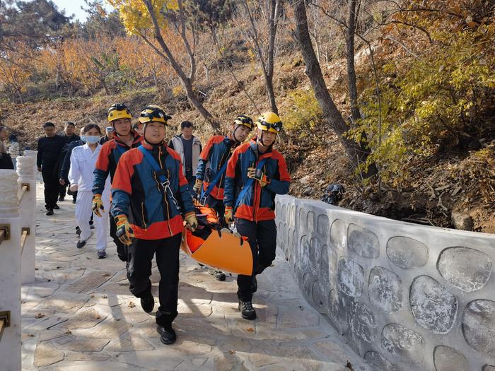 消防救援人员将晕倒男子抬下山。图源：怀柔区消防救援支队