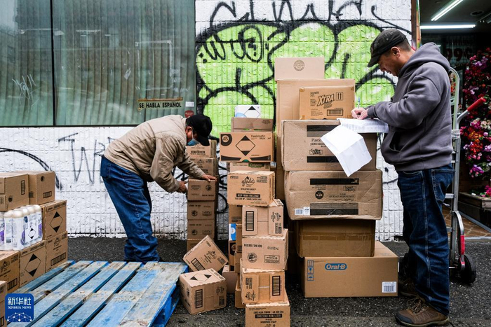 两名工人在美国纽约一家商店门口卸货。 资料图：新华社