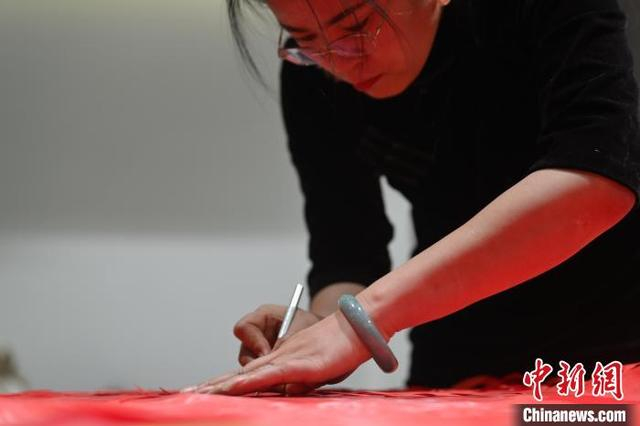 11月23日，甘肃省兰州市杨树珍剪纸工作室内，杨树珍制作剪纸汉服。中新社记者 李亚龙 摄