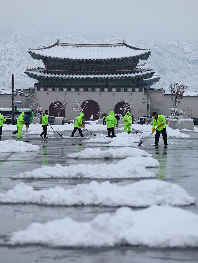 2024年11月28日，首尔光化门广场上，工人们正在扫雪。视觉中国 图