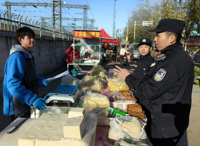 廊坊站派出所民警向铁路沿线附近的摊贩进行爱路护路宣传。 图源：北京铁路公安处