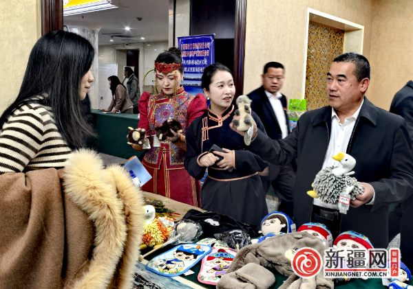 在文创产品展示区，和静县相关领导向游客介绍新推出的文创产品。（薛玲摄）