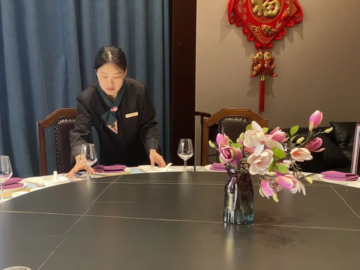 工作人员正在布置餐桌。崔宁 摄