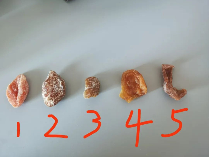 ▲新京报记者购买的5个“枇杷干”样品，经行业人士鉴定，仅样品4、5为真。新京报记者 刘欢 摄