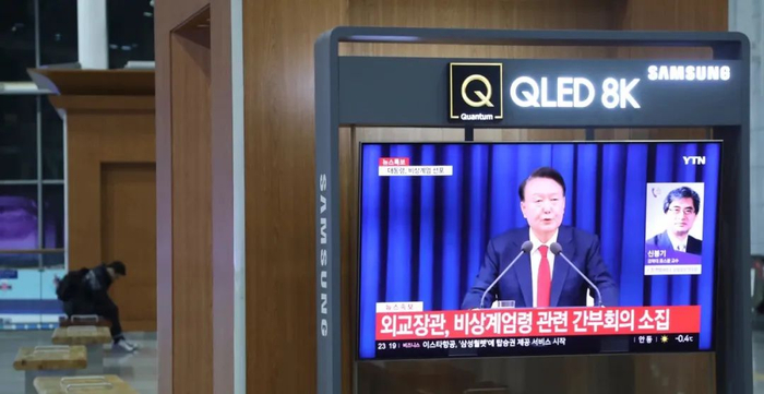 12月3日，在韩国首尔火车站，电视上播放总统宣布紧急戒严令的画面。图片来源：新华社