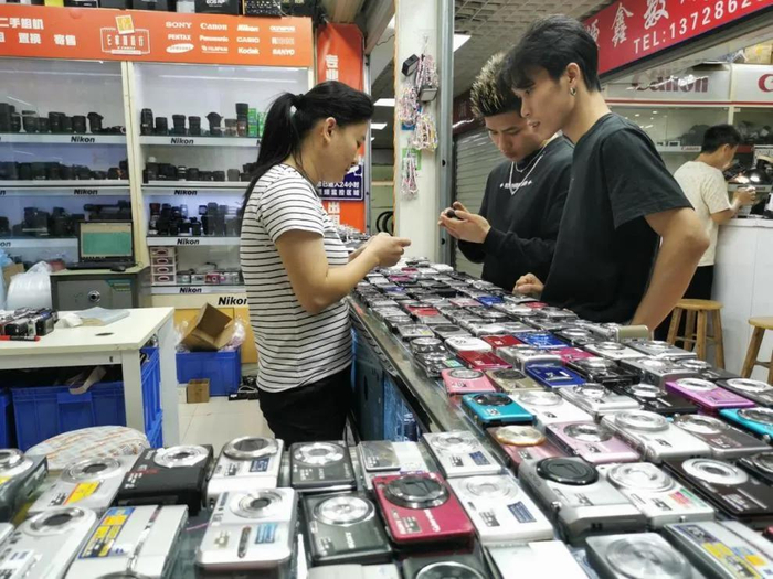 11月5日，两位年轻人在深圳华强北的现代之窗数码广场挑选CCD相机。新华网记者 王丰 摄