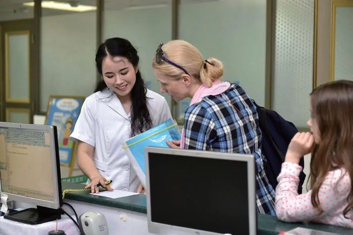 中山大学附属第五医院护士（左）为外国患者导诊（梁旭/摄）