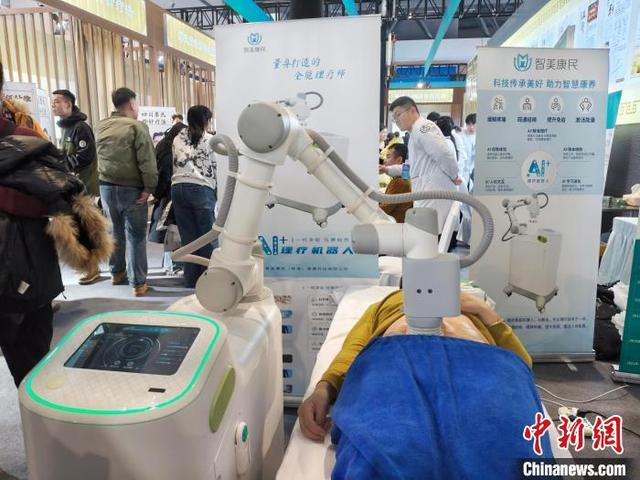 智能AI服务推拿机器人正在为体验者推拿。谭伟旗 摄