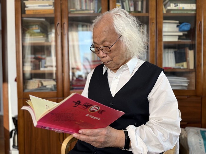 12月7日，刘魁立在家中翻阅《中国节典——四大传统节日》。新京报记者 张建林 摄