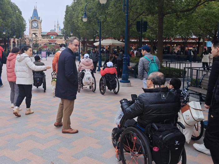 12月10日，残特殊需要人士驾驶电动轮椅进入上海迪士尼乐园游玩。新京报贝壳财经记者俞金旻摄