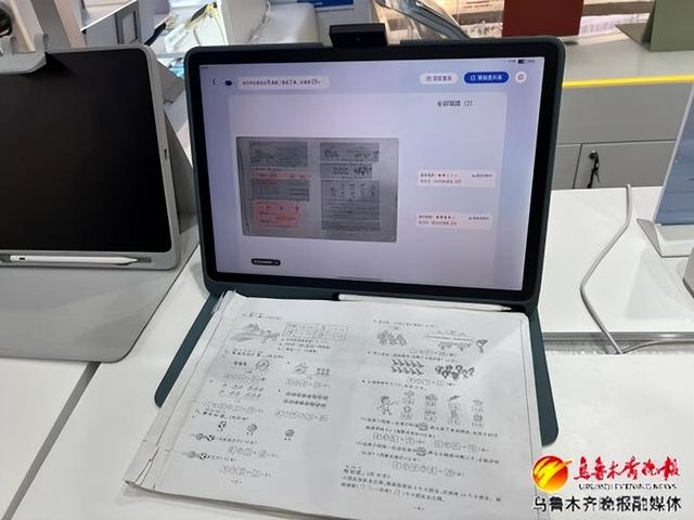 　　作业帮的一款学习机可以通过顶端伸出的摄像头，对桌上作业本进行扫描。记者王煜摄