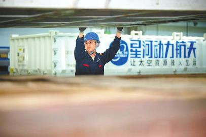 　　四川星河动力空间科技有限公司飞行器总装制造基地装配车间，工作人员协助起吊机将首枚“资阳造”运载火箭装车。 韩成玺 摄