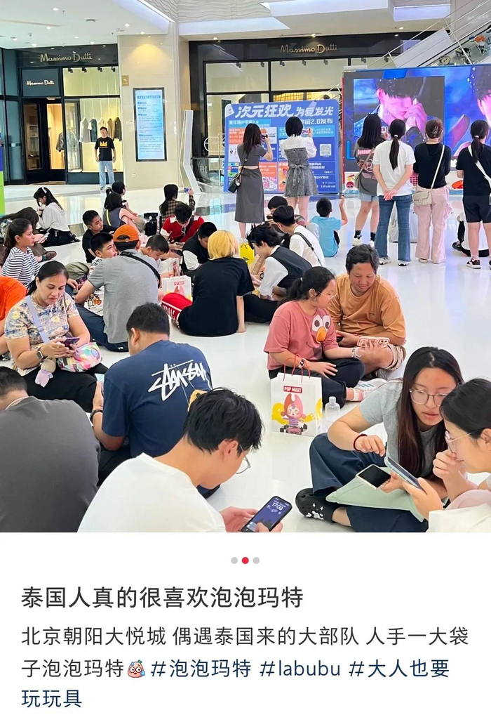 有网友在社媒上分享泡泡玛特的泰国门店外，人们正席地而坐等候进店
