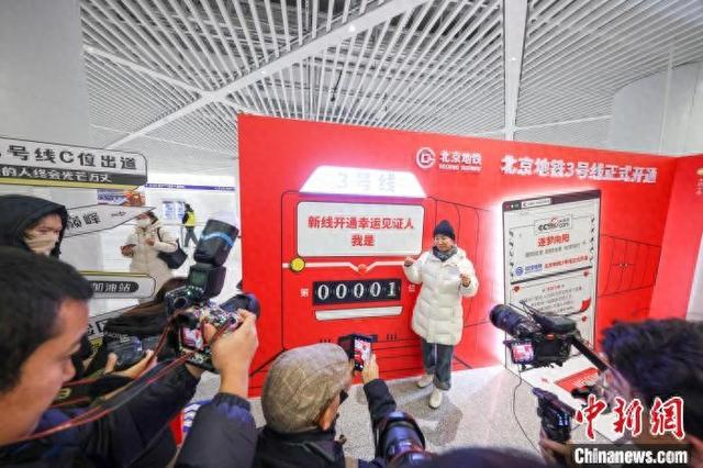 12月15日，北京地铁3号线朝阳站内，拿到001号纪念车票的乘客在打卡拍照。记者 贾天勇 摄