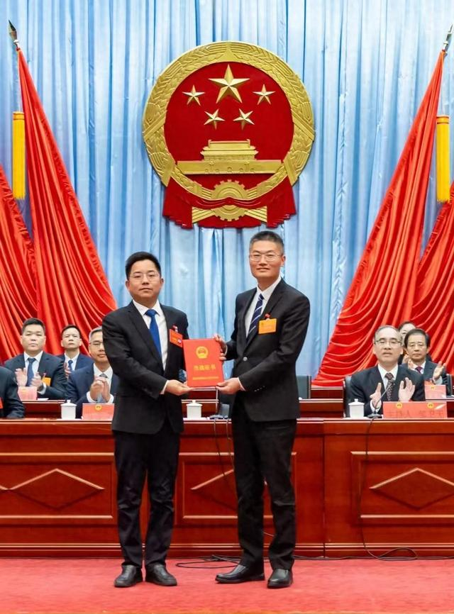 肇庆市端州区委书记张浩龙(左)为新当选的区长贺丹(右)颁发当选证书文