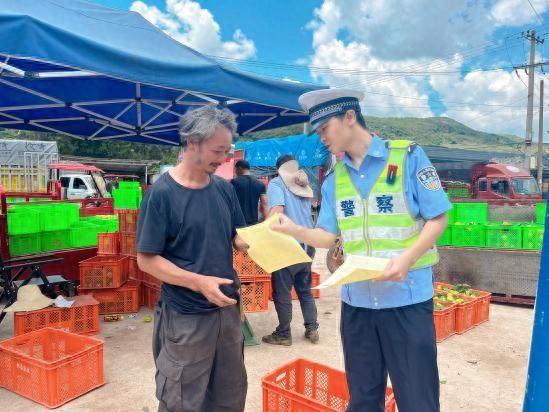 图为民警向果农讲解交通安全知识。华宁县公安局交警大队供图