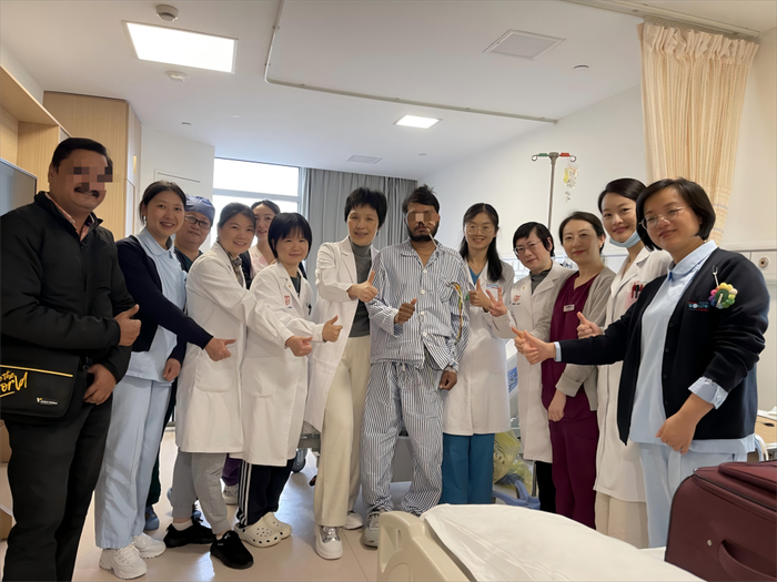 经过治疗，约翰最终能站起来。出院前，他与华山医院国际医疗中心医疗团队合影。华山医院 供图