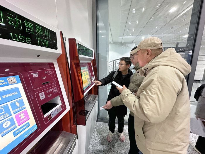 12月28日5点半，旅客在廊坊北站取票留念。新京报记者 王贵彬 摄