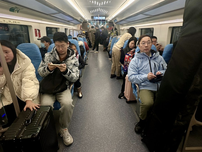 列车上带着大包小包的乘客 戚颖璞 摄